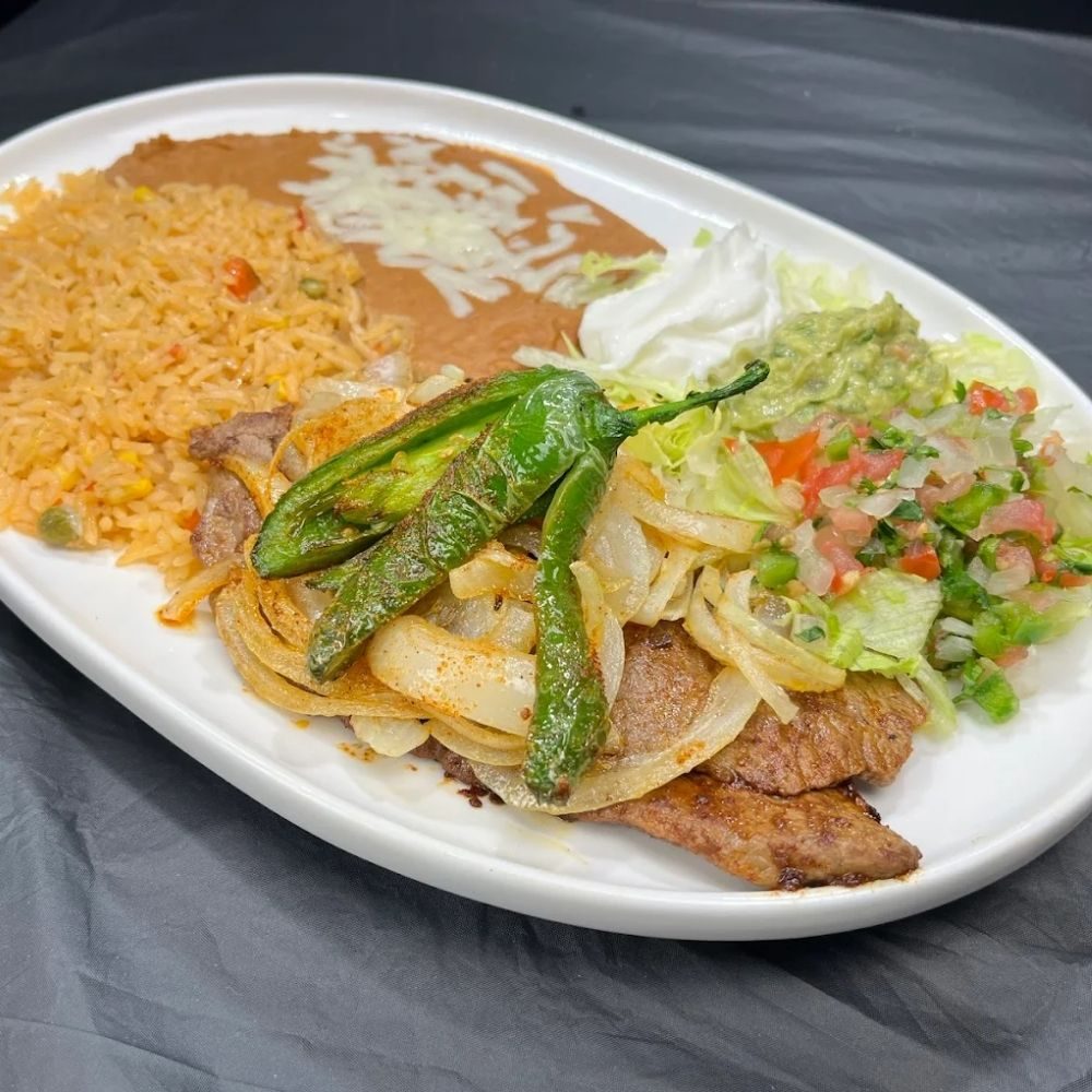 Grilled steak with onions and peppers, rice and beans